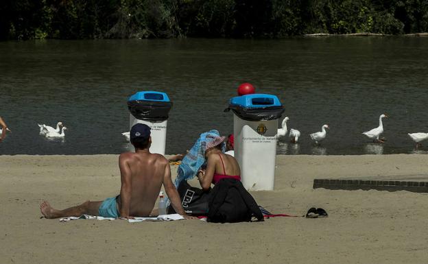 Dos jóvenes toman el sol en Valladolid. 