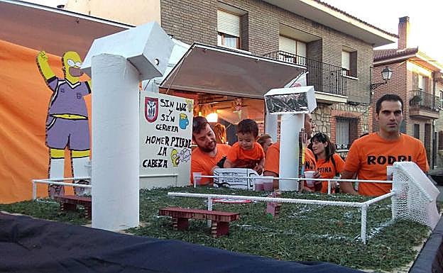 Vecinos de la localidad, junto a una de las carrozas en unas fiestas pasadas. 