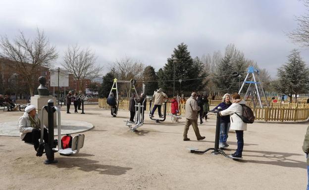 Varias personas disfrutan de los aparatos biosaludables en un parque de la ciudad.