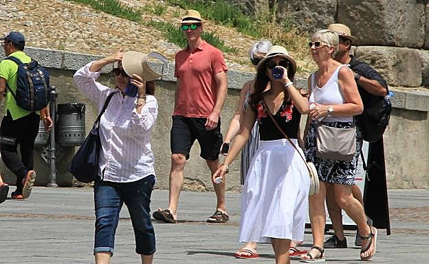 Turistas con viseras y botellines por las calles de Segovia. Antonio Tanarro