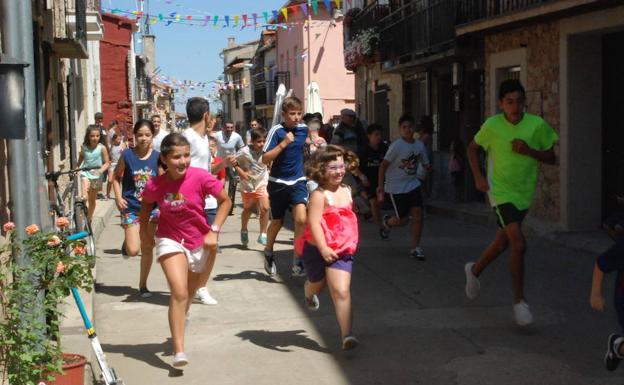 Los niños corriendo por la calle Larga delante de los carretones.