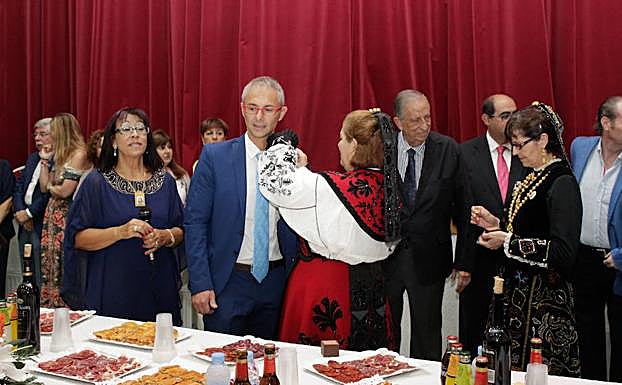 El rector recibe el botón charro otorgado por la asociación vecinal, con Estella a su izquierda. 