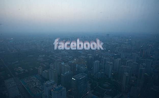 El logotipo de Facebook se refleja en una ventanal desde el que se divisa una panorámica de Pekín.