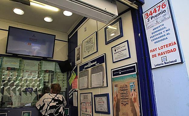 Una mujer compra lotería en una administración.