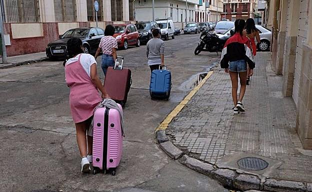 Las niñas trasladan sus pertenencias a un lugar seguro en Melilla, después de ser desvalijadas en el centro de acogida.
