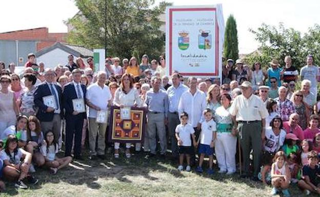 Asistentes a los actos celebrados en Villoslada, junto al cartel que recuerda el hermanamiento.