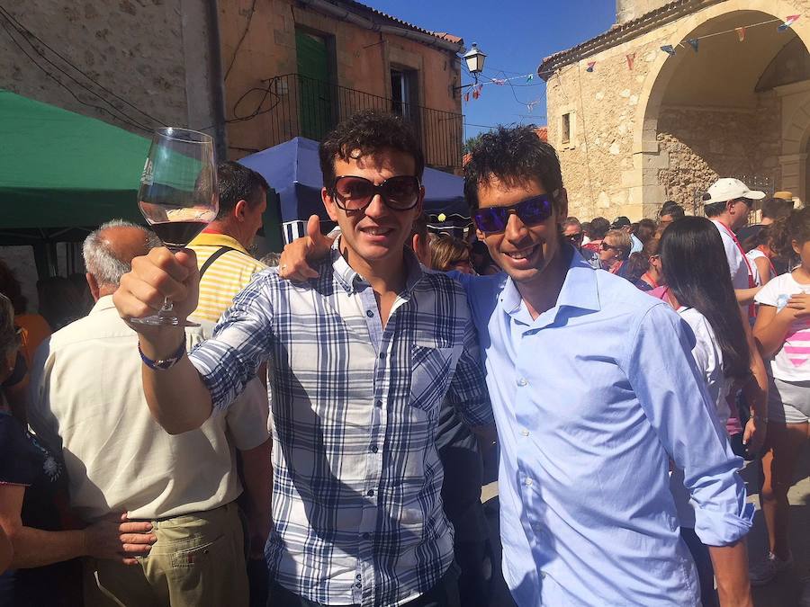 Los atletas Juan Carlos Higuero y Javier Guerra brindan con vino durante la fiesta en Valtiendas.