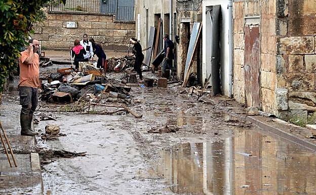 Varias personas trabajan para limpiar una de las zonas afectadas por las inundaciones.