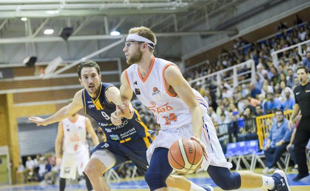 Calvin Hermanson mira a canasta ante la defensa de Pérez. 