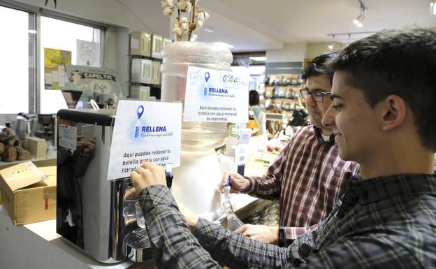 Andrés y Jorge, alumno y subdirector del colegio mayor Menéndez Pelayo, rellenan sus botellas con los puntos de agua de Come Sano.