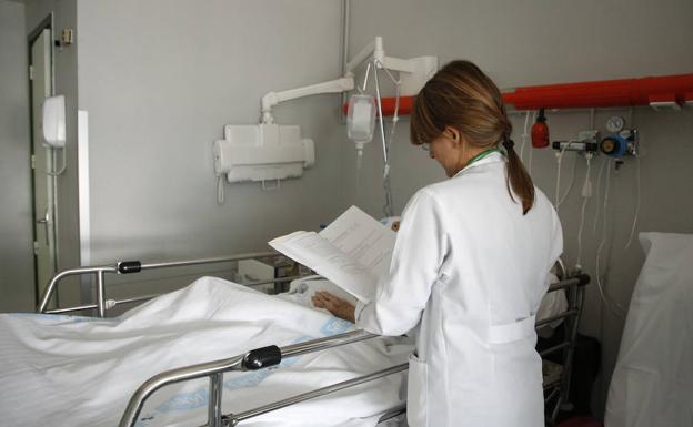La doctora Carmen Pablos, junto a un paciente en la planta de hospitalización de Traumatología. 