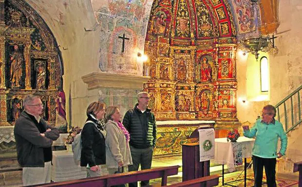 Eutimia Arranz explica a un grupo de turistas la historia de la iglesia de San Salvador, en Pozancos.