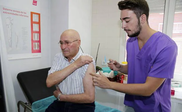 Un enfermero vacuna a una persona mayor con la antigripal en Palencia