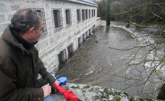 Un vecino observa el desbordamiento del Eresma en Segovia en 2014, en la Casa de la Moneda. 