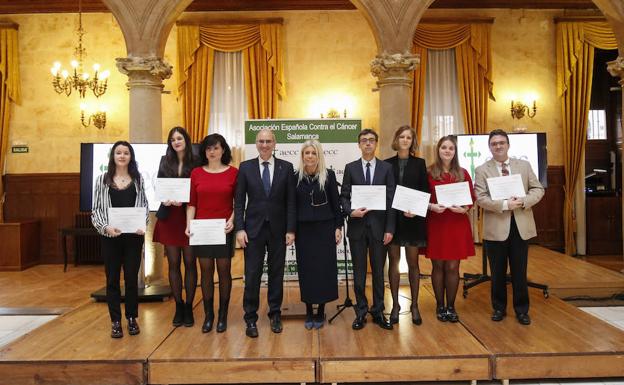 Los investigadores (cinco mujeres y dos hombres), tras recibir las becas junto a la presidenta de la AECC y el responsable de la Diputación. 