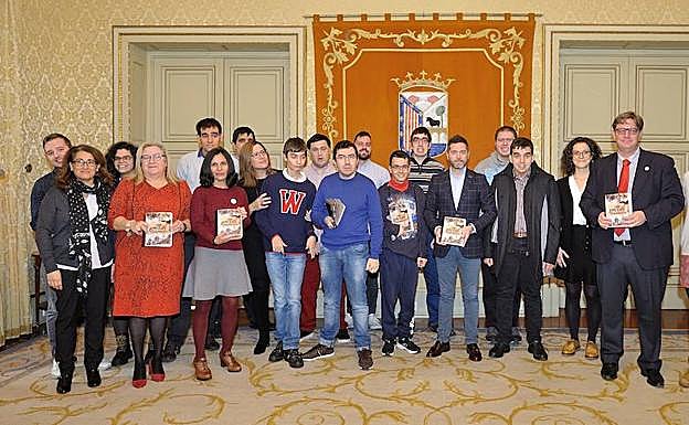 Miembros de Ariadna, familiares, trabajadores y representantes municipales posan con las guías. 