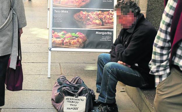 Un hombre pide limosna en plena calle, en el centro de Segovia. 