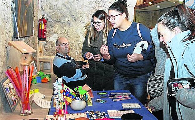Varias jóvenes observan los artículos expuestos en la exposición. 