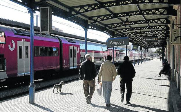 El andén de la estación antigua casi desierta de pasajeros, y con el tren interregional estacionado. 