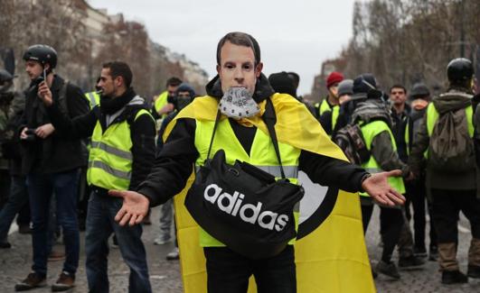 Un manifestante porta una careta de Macron. 
