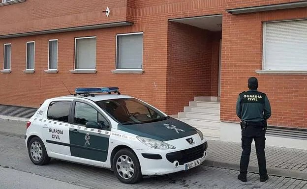 Un agente de la Guardia Civil de Segovia, junto a su vehículo. 