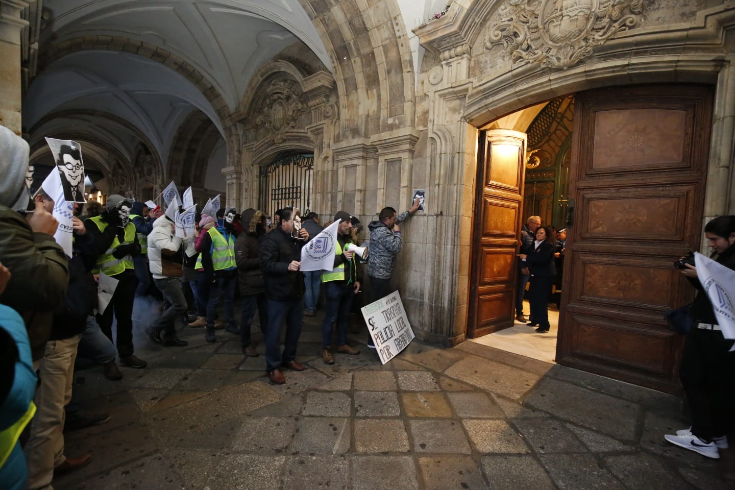 Fuera del salón de plenos, desde minutos antes de comenzar la sesión, medio centenar de agentes y representantes sindicales se ha concentrado para pedir mejoras salariales y de material laboral, para lo que han mostrado su descontento con pancartas y la utilización de silbatos y megáfonos