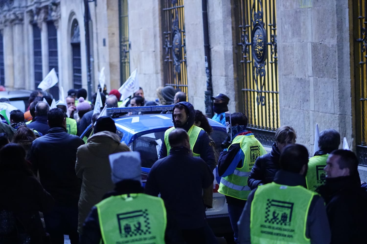 Fuera del salón de plenos, desde minutos antes de comenzar la sesión, medio centenar de agentes y representantes sindicales se ha concentrado para pedir mejoras salariales y de material laboral, para lo que han mostrado su descontento con pancartas y la utilización de silbatos y megáfonos