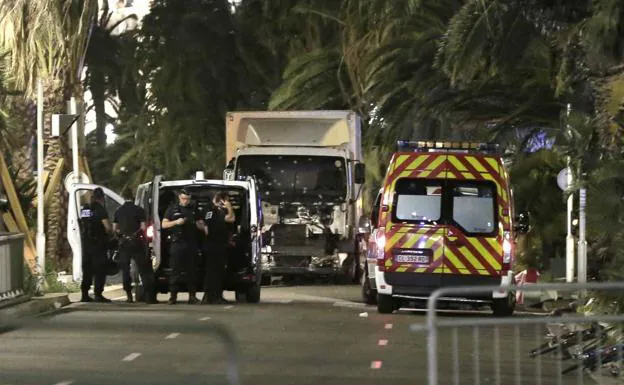 Policías permanecen junto al camión que arremetió contra una multitud durante la Fiesta Nacional del 14 de julio en Niza.