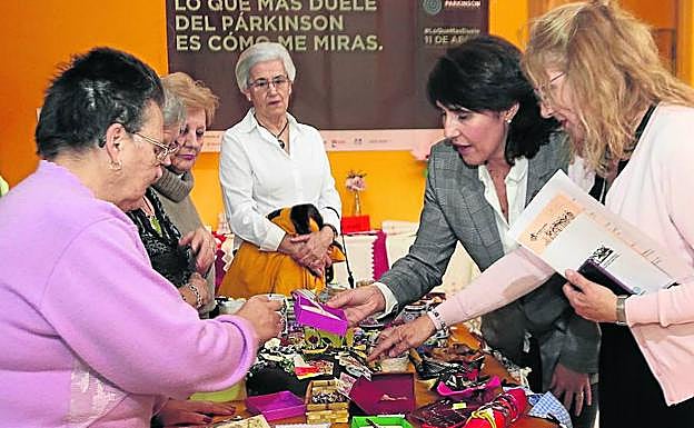 Carmen Well, gerente territorial de Servicios Sociales de Segovia (segunda por la derecha), observa algunos de los artículos del rastrillo. 