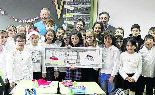 La alumna ganadora, en el centro, muestra su dibujo.