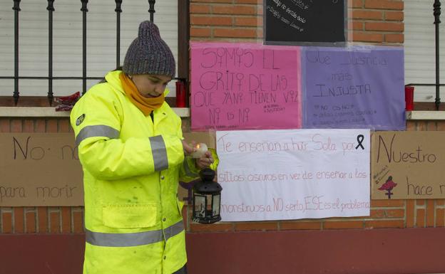 Ana Hernández enciende una vela junto a la fachada del Ayuntamiento de Villabuena del Puente.