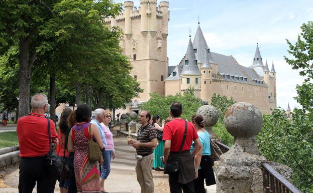 Un guía informa a un grupo de turistas sobre el Alcázar. 
