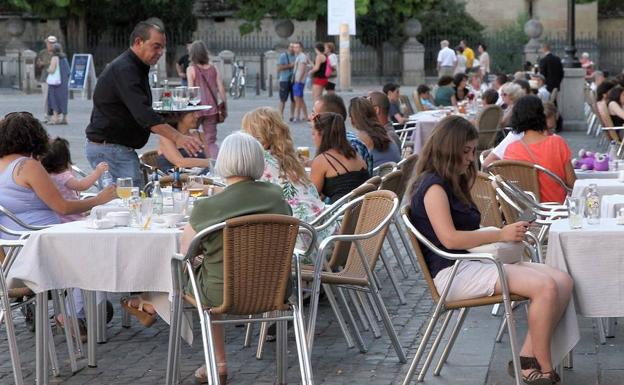 Un camarero sirve una mesa en una terraza de la Plaza Mayor.