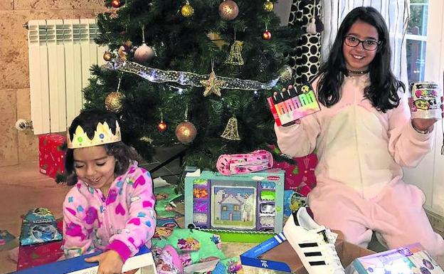 Triana y Claudia Sánchez, a los pies del árbol, con sus regalos de los Reyes Magos.