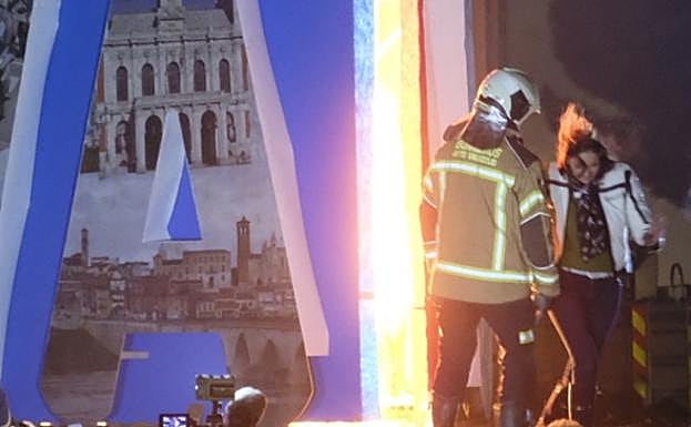 Un bombero se acerca a la ministra justo después de prender la falla.