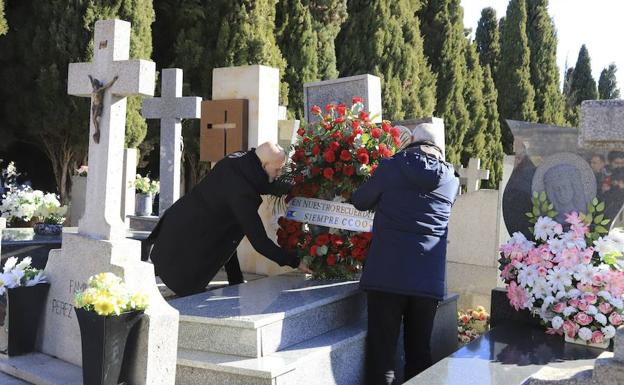 Alejandro Ruiz y Emilio Pérez coloccan una corona en la tumba de Holgado.