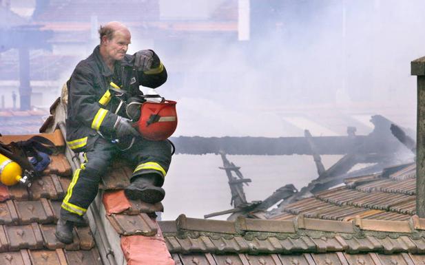 Un bombero descansa sobre el tejado de un inmueble.