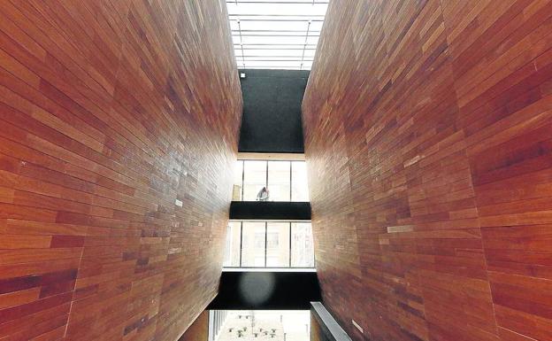 Bloques de madera a ambos lados del interior a partir de los cuales se pueden observar las distintas alturas del nuevo edificio del campus María Zambrano de Segovia. 