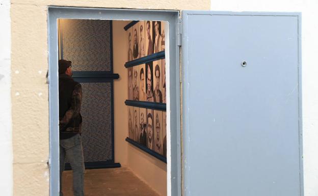 Un hombre observa las fotografías de algunas víctimas del franquismo en una de las celdas de la cárcel.