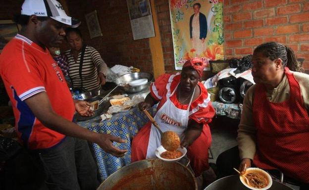 Vecinos de La Quebrada reparten el plato del día. 