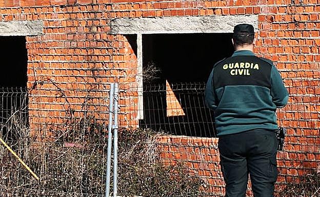 Un agente ante una edificación a medio hacer. 