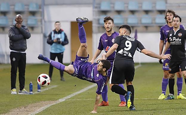Adri intenta evitar que salga el balón ante el delantero del Sporting Uxama David Miranda. 