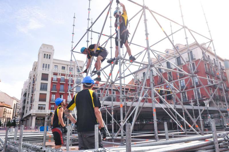 Varios operarios trabajan en el montaje de un escenario en la Plaza Mayor de Valladolid. 