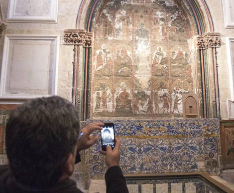 Una persona fotografía las pinturas. 