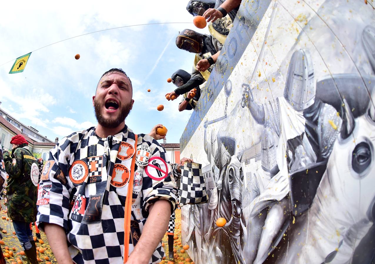 El histórico Carnaval de Ivrea, localidad de Piamonte en la provincia de Turín, representa la guerra civil entre el pueblo y las tropas reales napoleónicas, el día después de la muerte del odiado tirano Raineri de Bramante a manos de la 'Mugnaia' | Los equipos de lanzadores de naranjas a pie (el pueblo) defienden sus plazas de los lanzadores de los carros (el Estado Mayor Napoleónico) a golpe de naranja