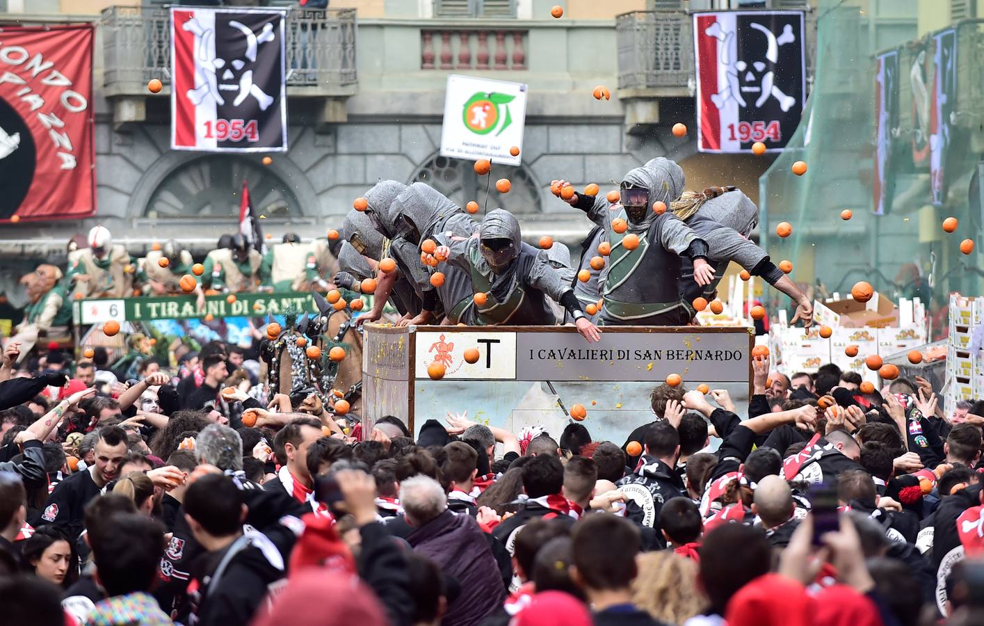El histórico Carnaval de Ivrea, localidad de Piamonte en la provincia de Turín, representa la guerra civil entre el pueblo y las tropas reales napoleónicas, el día después de la muerte del odiado tirano Raineri de Bramante a manos de la 'Mugnaia' | Los equipos de lanzadores de naranjas a pie (el pueblo) defienden sus plazas de los lanzadores de los carros (el Estado Mayor Napoleónico) a golpe de naranja