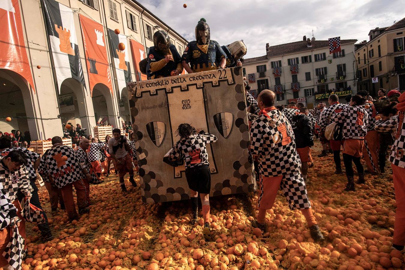 El histórico Carnaval de Ivrea, localidad de Piamonte en la provincia de Turín, representa la guerra civil entre el pueblo y las tropas reales napoleónicas, el día después de la muerte del odiado tirano Raineri de Bramante a manos de la 'Mugnaia' | Los equipos de lanzadores de naranjas a pie (el pueblo) defienden sus plazas de los lanzadores de los carros (el Estado Mayor Napoleónico) a golpe de naranja