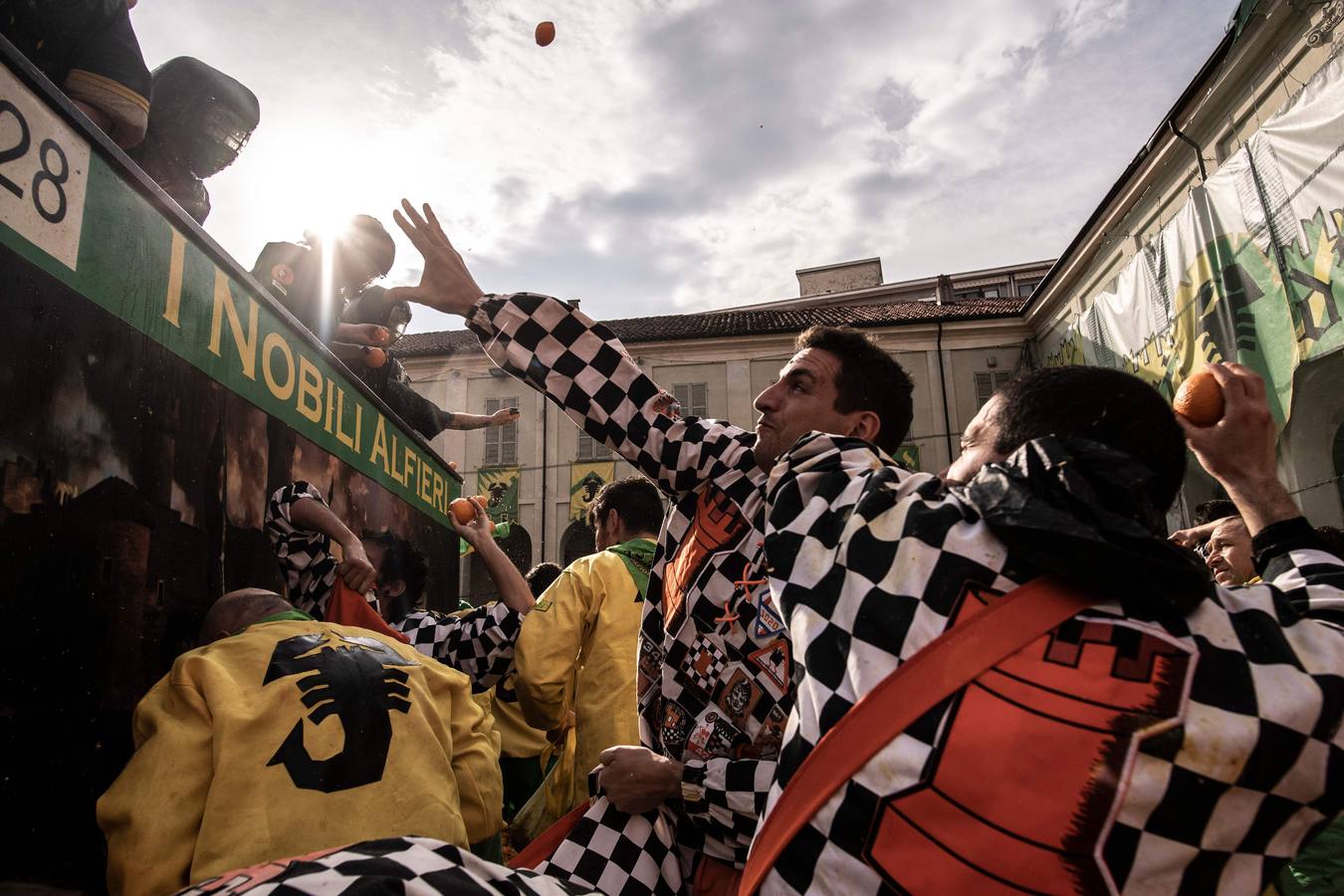 El histórico Carnaval de Ivrea, localidad de Piamonte en la provincia de Turín, representa la guerra civil entre el pueblo y las tropas reales napoleónicas, el día después de la muerte del odiado tirano Raineri de Bramante a manos de la 'Mugnaia' | Los equipos de lanzadores de naranjas a pie (el pueblo) defienden sus plazas de los lanzadores de los carros (el Estado Mayor Napoleónico) a golpe de naranja