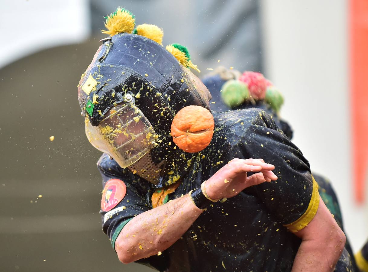 El histórico Carnaval de Ivrea, localidad de Piamonte en la provincia de Turín, representa la guerra civil entre el pueblo y las tropas reales napoleónicas, el día después de la muerte del odiado tirano Raineri de Bramante a manos de la 'Mugnaia' | Los equipos de lanzadores de naranjas a pie (el pueblo) defienden sus plazas de los lanzadores de los carros (el Estado Mayor Napoleónico) a golpe de naranja