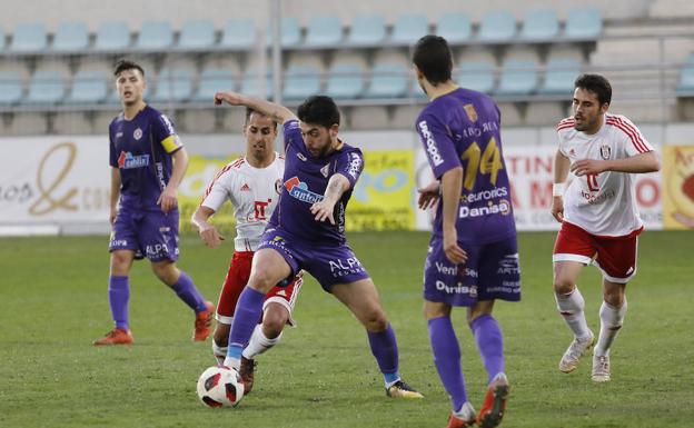 Zubi conduce el balón ante la mirada de Adri Pérez. 